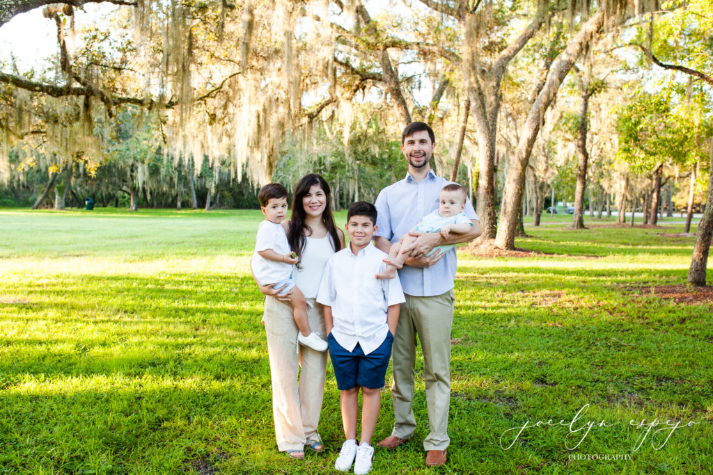 Mom and Dad with their 3 sons in a park.