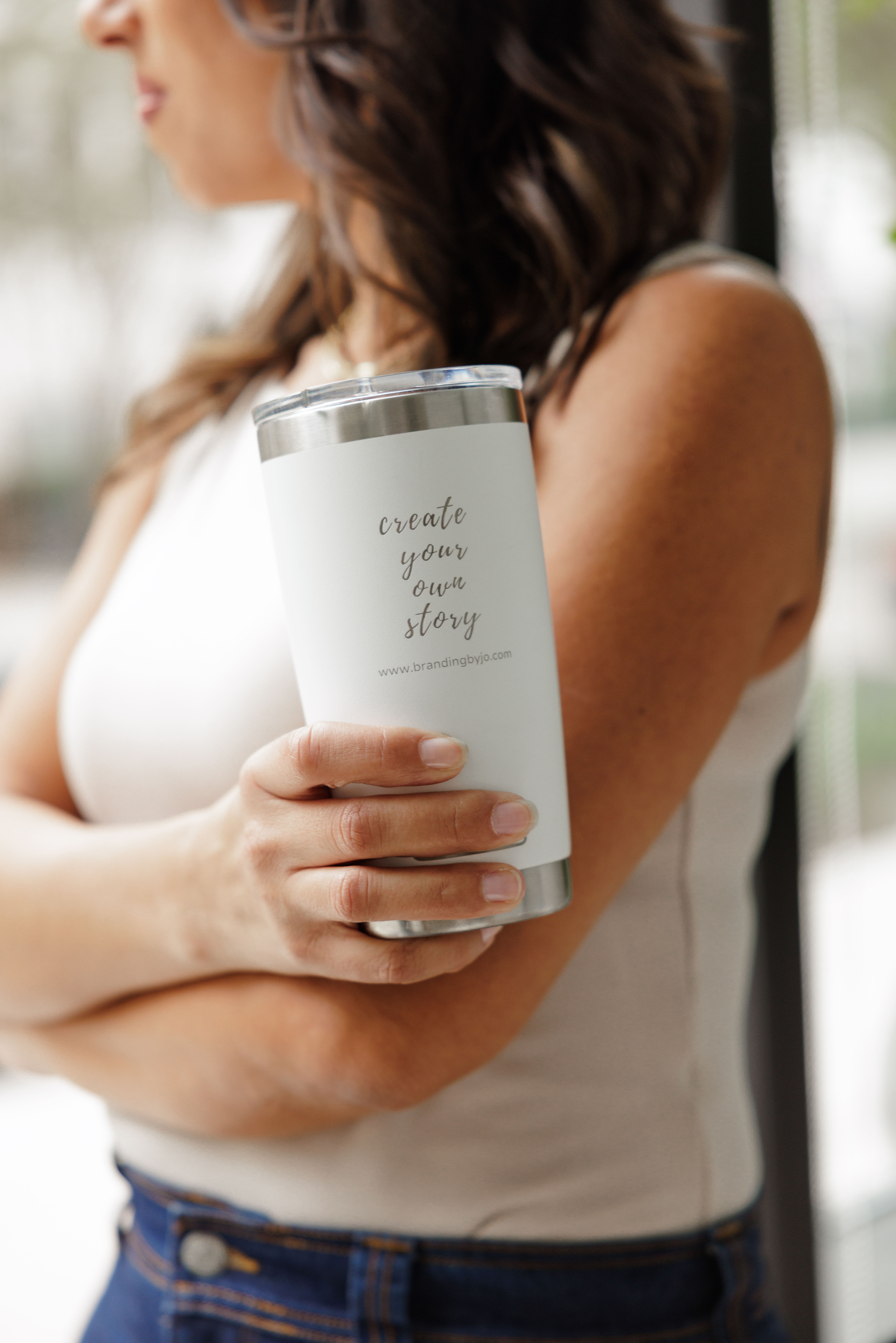 Woman holding a white tumbler that says “reads you your story,” captured during a lifestyle brand photo session.